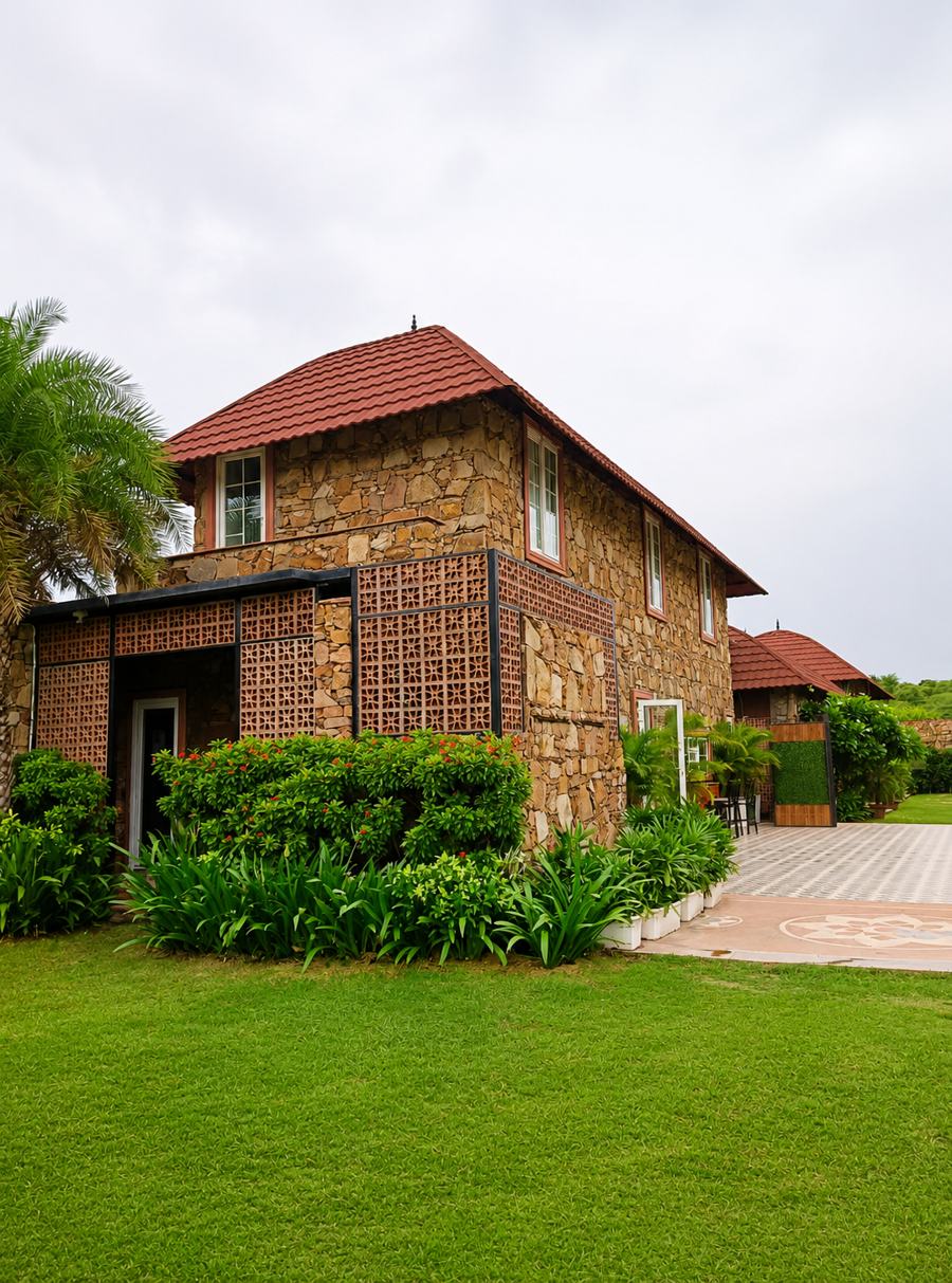 Qila estate across the lawn, stone walls and clay tile roof