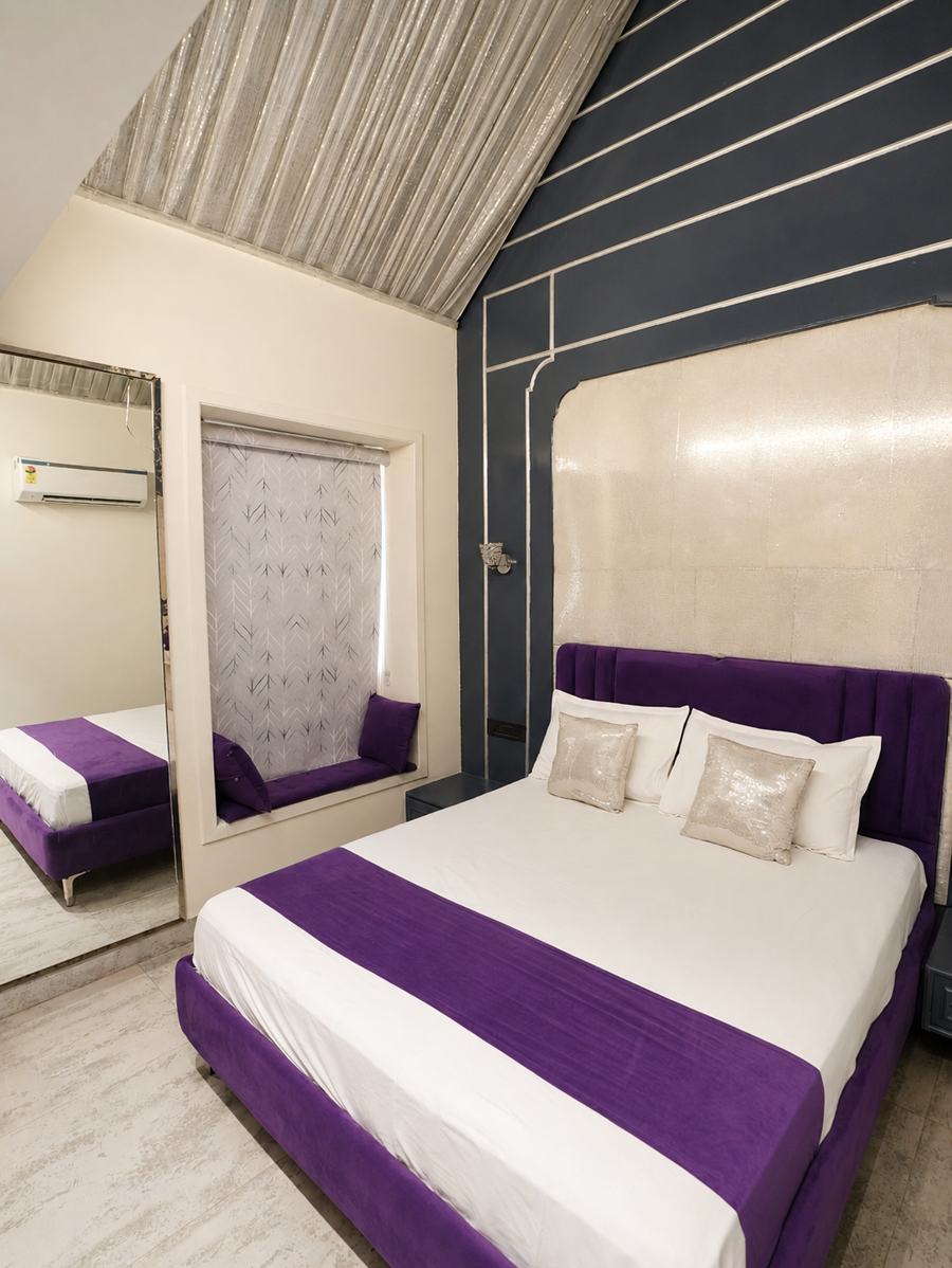 Purple velvet bed with a grey slate wall